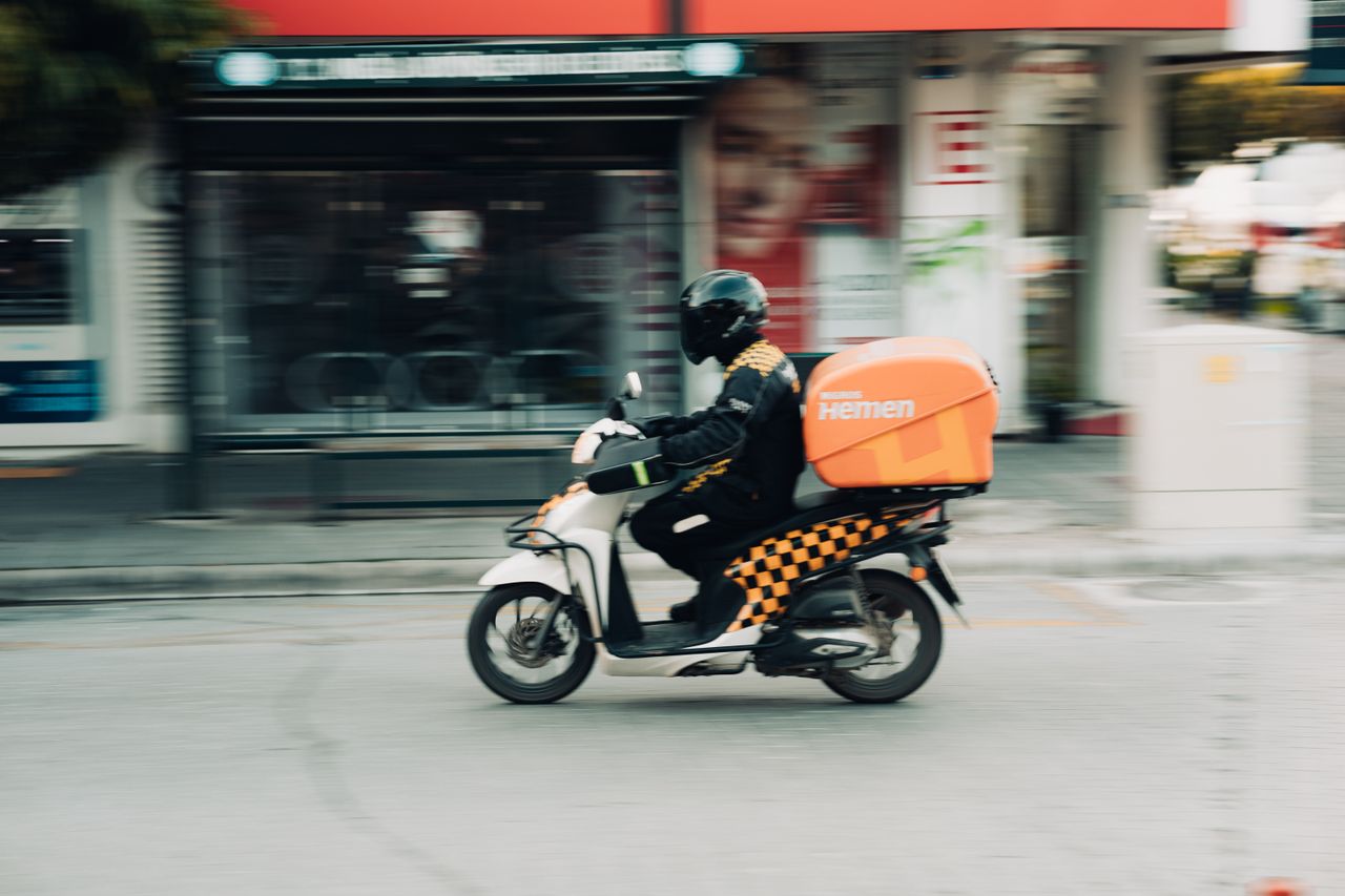 Crafting Captivating Headlines: Your awesome post title goes here A delivery rider on a motor scooter speeds through city streets capturing urban transportation dynamics.