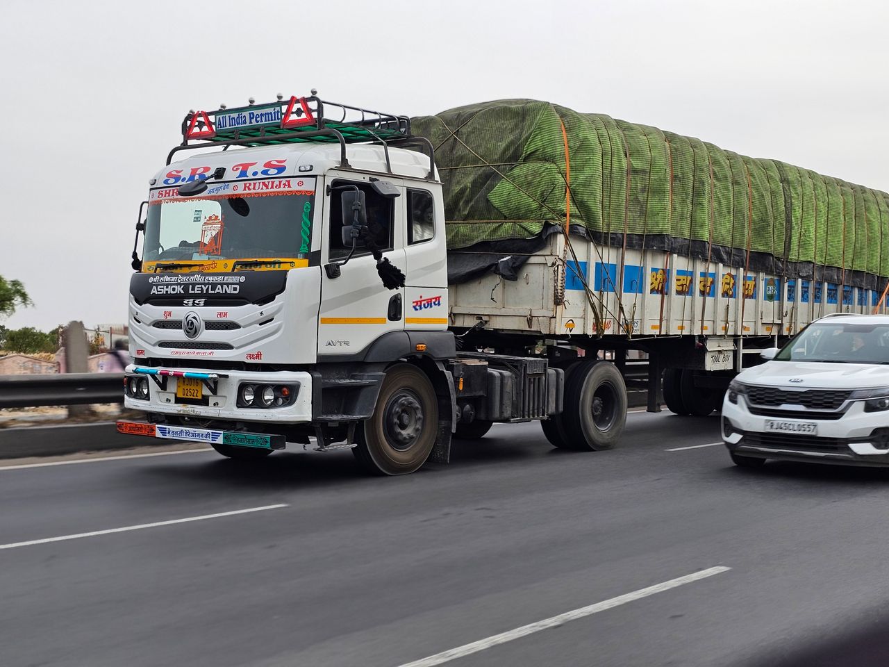 About Ashok Leyland semi-truck transporting goods on a busy Indian highway, showcasing modern logistics.