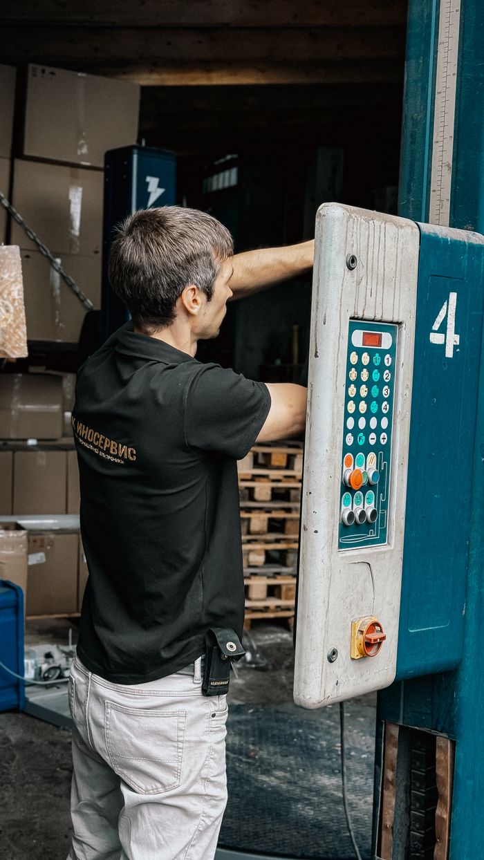 Home Man operating a loading dock panel, managing warehouse logistics for efficient operations.