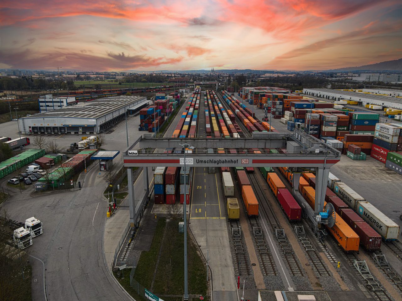 Home Aerial view of a bustling shipping yard with colorful containers at sunset, highlighting logistics.